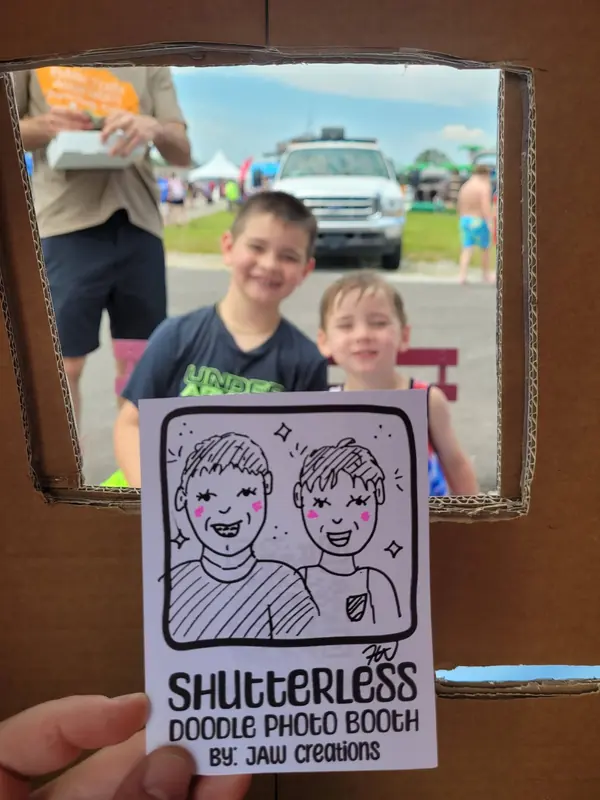 Two boys behind the booth frame with their duo doodle