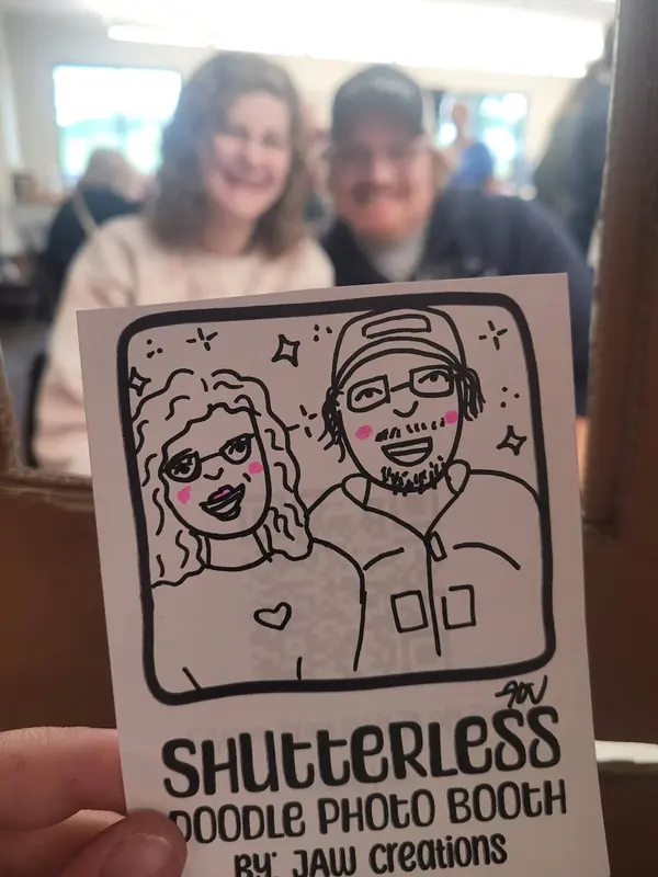 Couple behind the booth frame with their doodle portrait