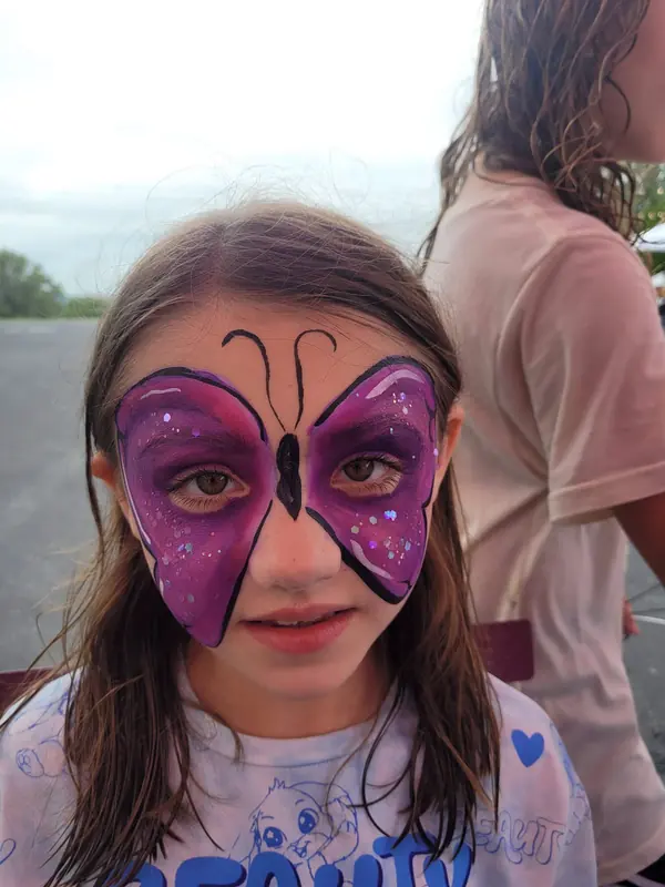 Girl with a purple butterfly face paint design