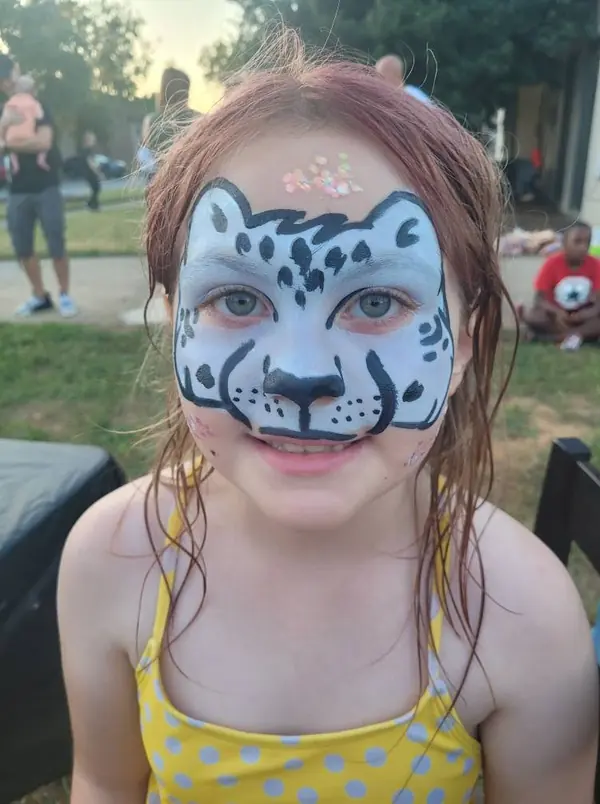 Child with a snow leopard face paint design