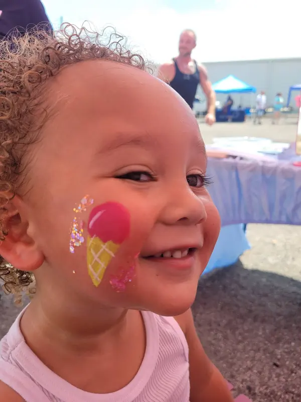 Toddler with an ice cream cone painted on her cheek