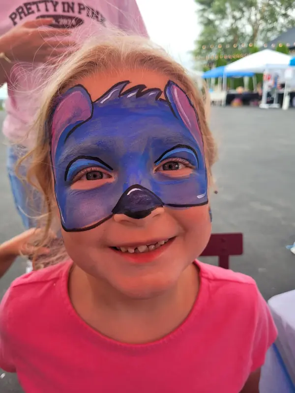 Child with a blue monster face paint design