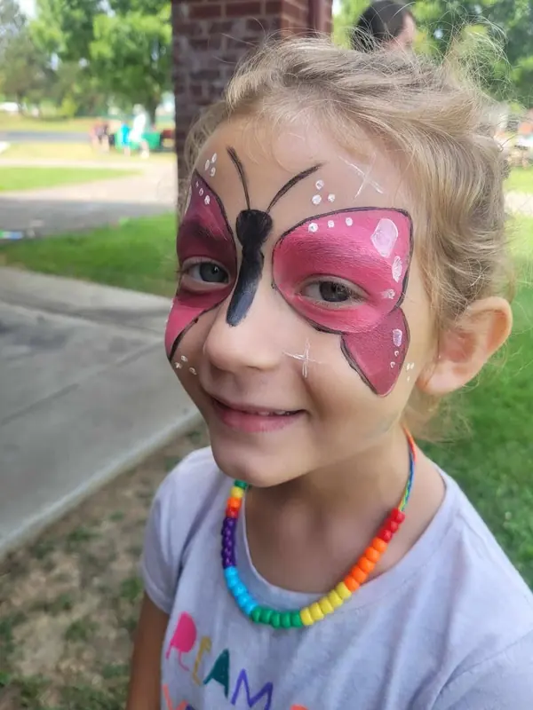 Girl with a pink butterfly face paint design