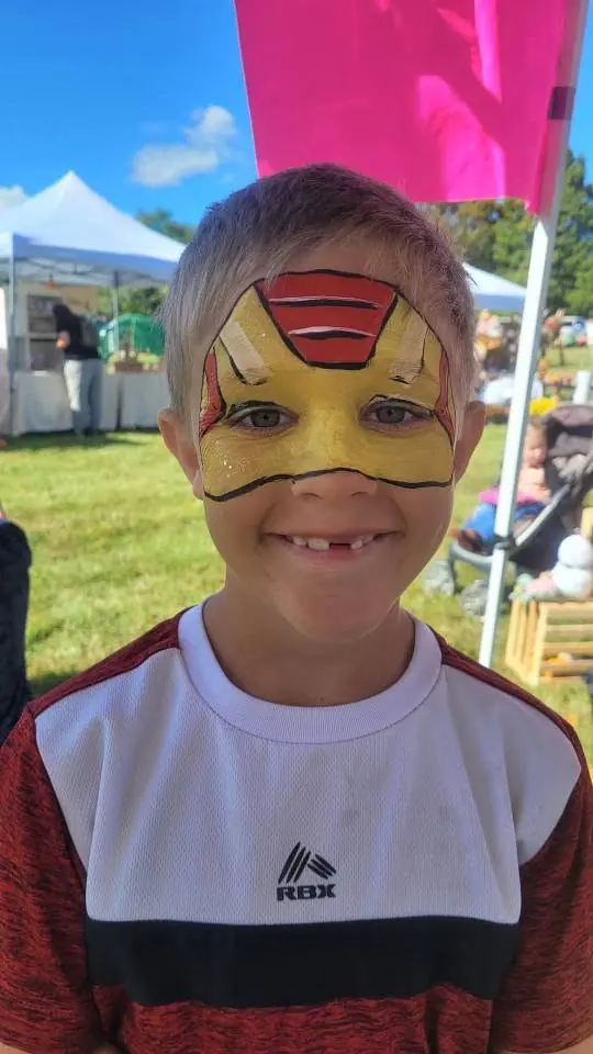 Boy with a red and gold superhero mask design