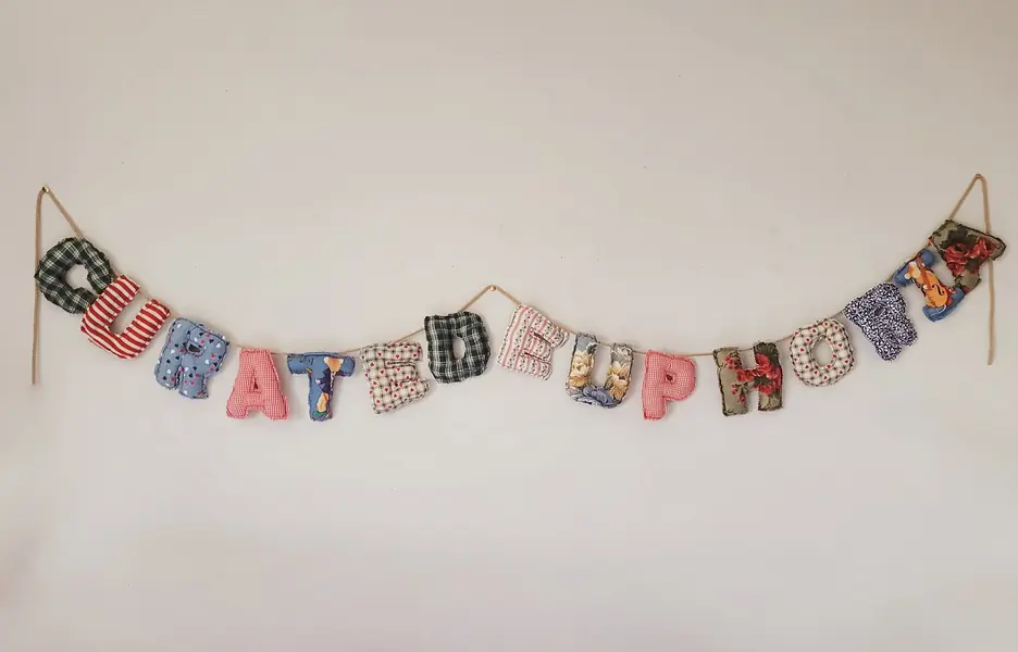 Patterned fabric letter banner hung on a wall