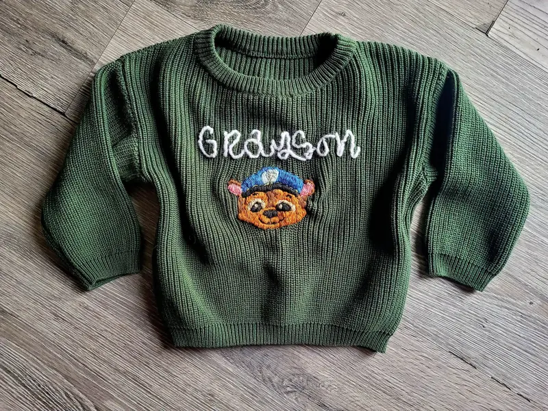 Green kids' sweater embroidered with the name Grayson and a mascot