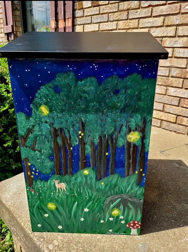 Outdoor box painted with a nighttime forest scene and fireflies