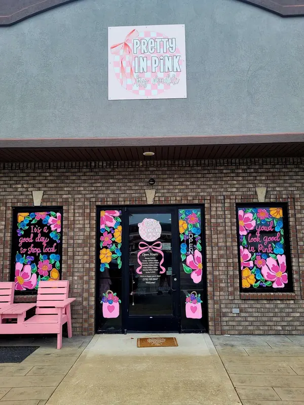 Bright floral storefront windows with a pink bench