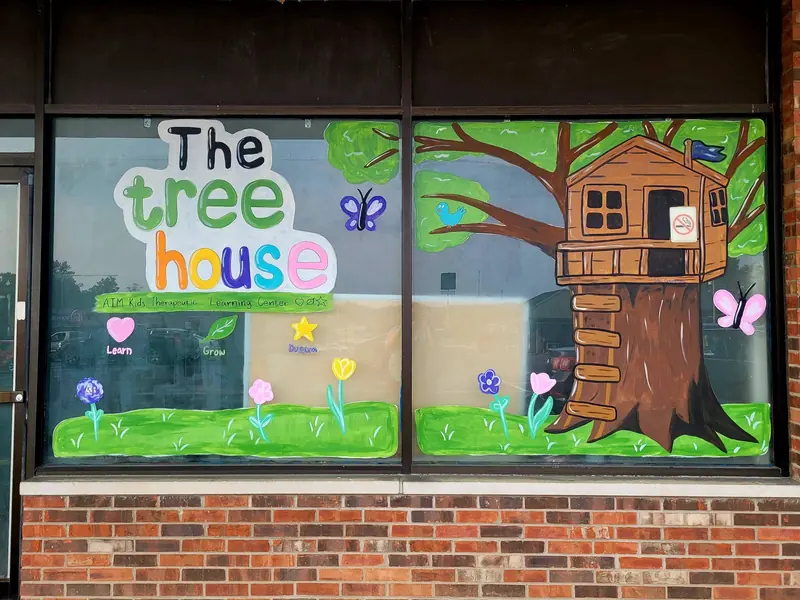 The Tree House window with a painted treehouse and garden